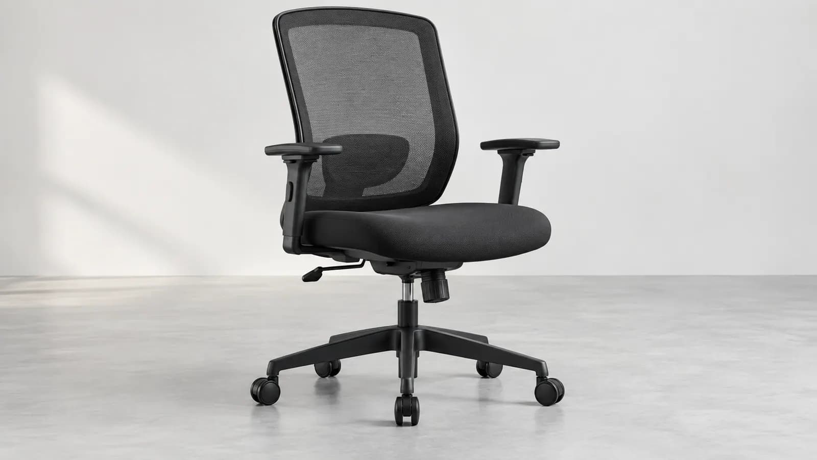 Unbranded ergonomic office chair with its full five-point base and caster footprint visible on a neutral studio floor