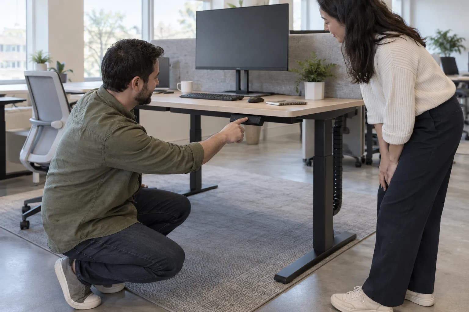 Illustrative office user and facilities specialist reviewing the reach of a handset on a shared desk mock-up