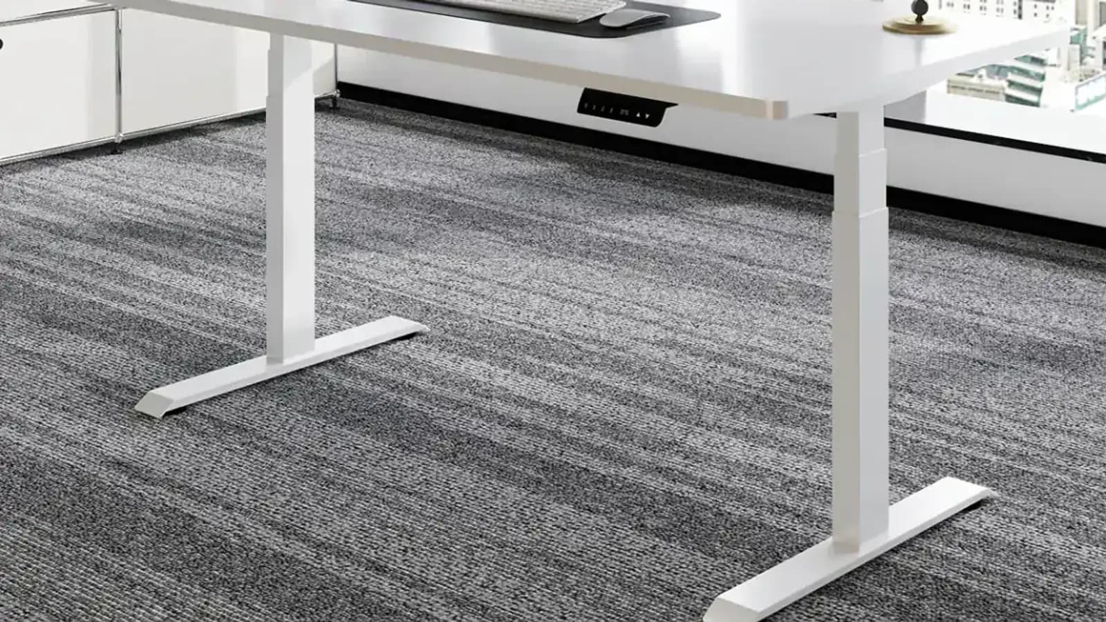 MENBRO height-adjustable desk base, control panel and work surface shown in a furnished office setting