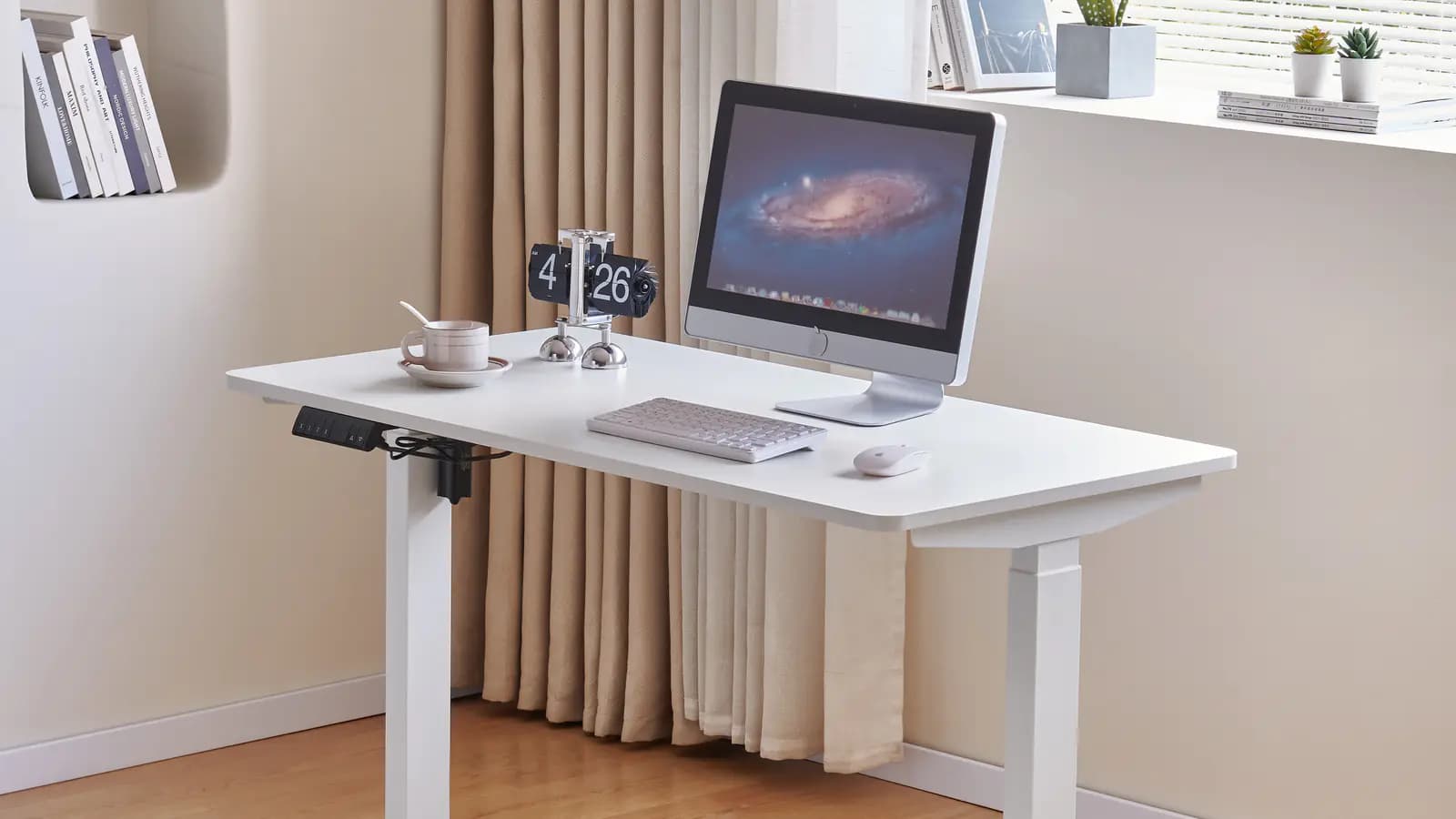 MENBRO white height-adjustable desk shown in a furnished workspace with its control panel and telescoping columns visible