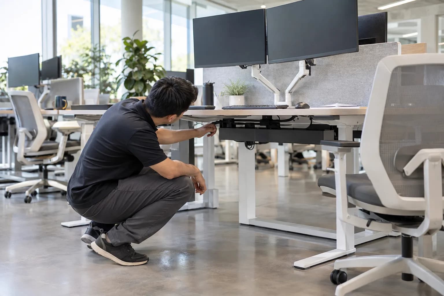 Unbranded shared height-adjustable desk with accessible under-desk cable route and service area